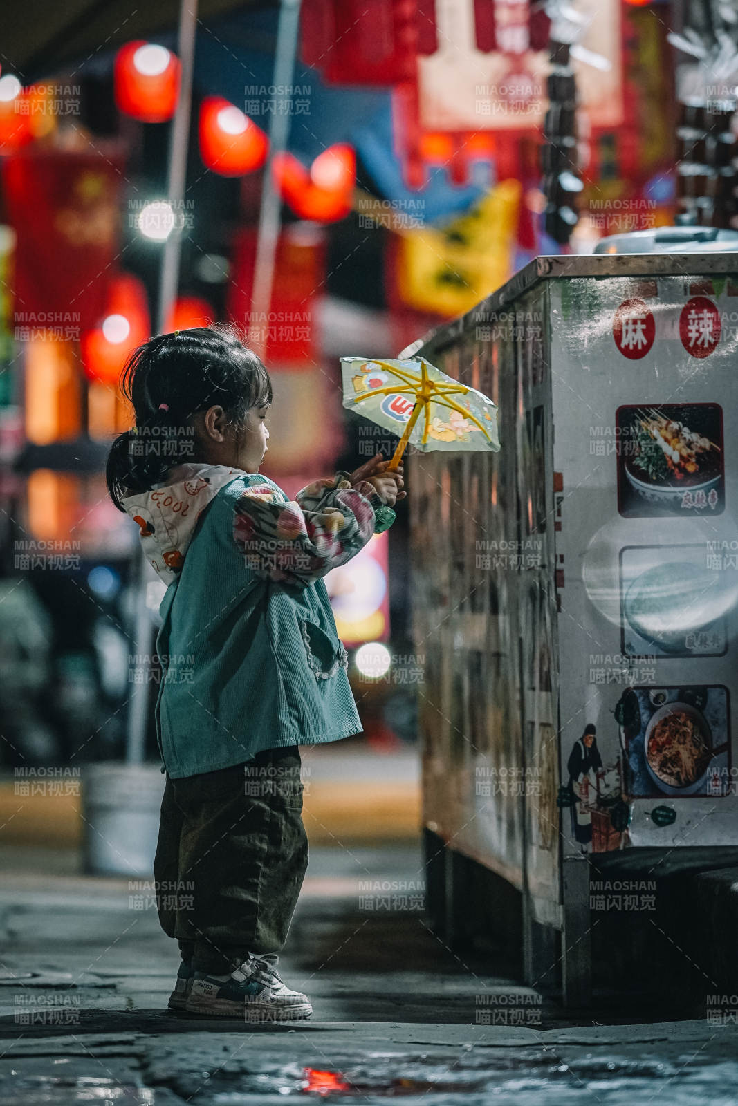 夜市小童撑伞望美食图片
