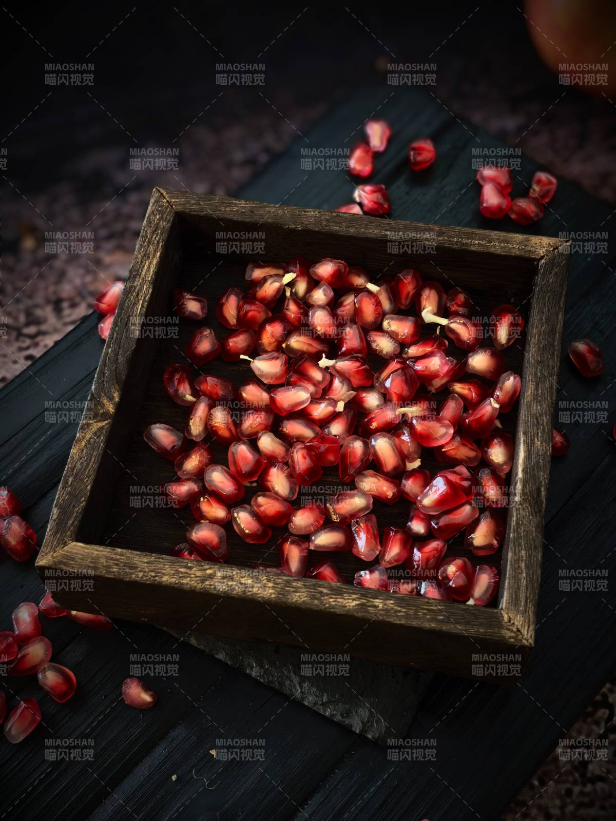 石榴籽在木盒中散落图片