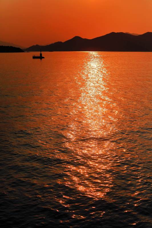 夕阳映海 孤舟远山图片