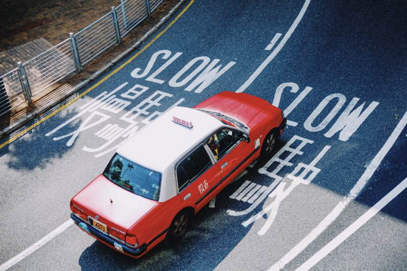 香港红色出租车驶过 慢行 标识图片