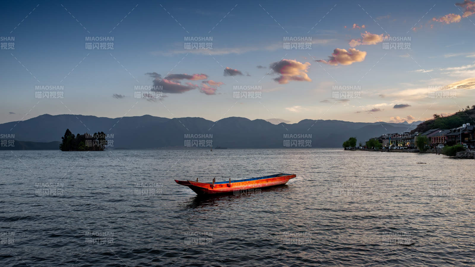 泸沽湖畔日落中的小舟图片