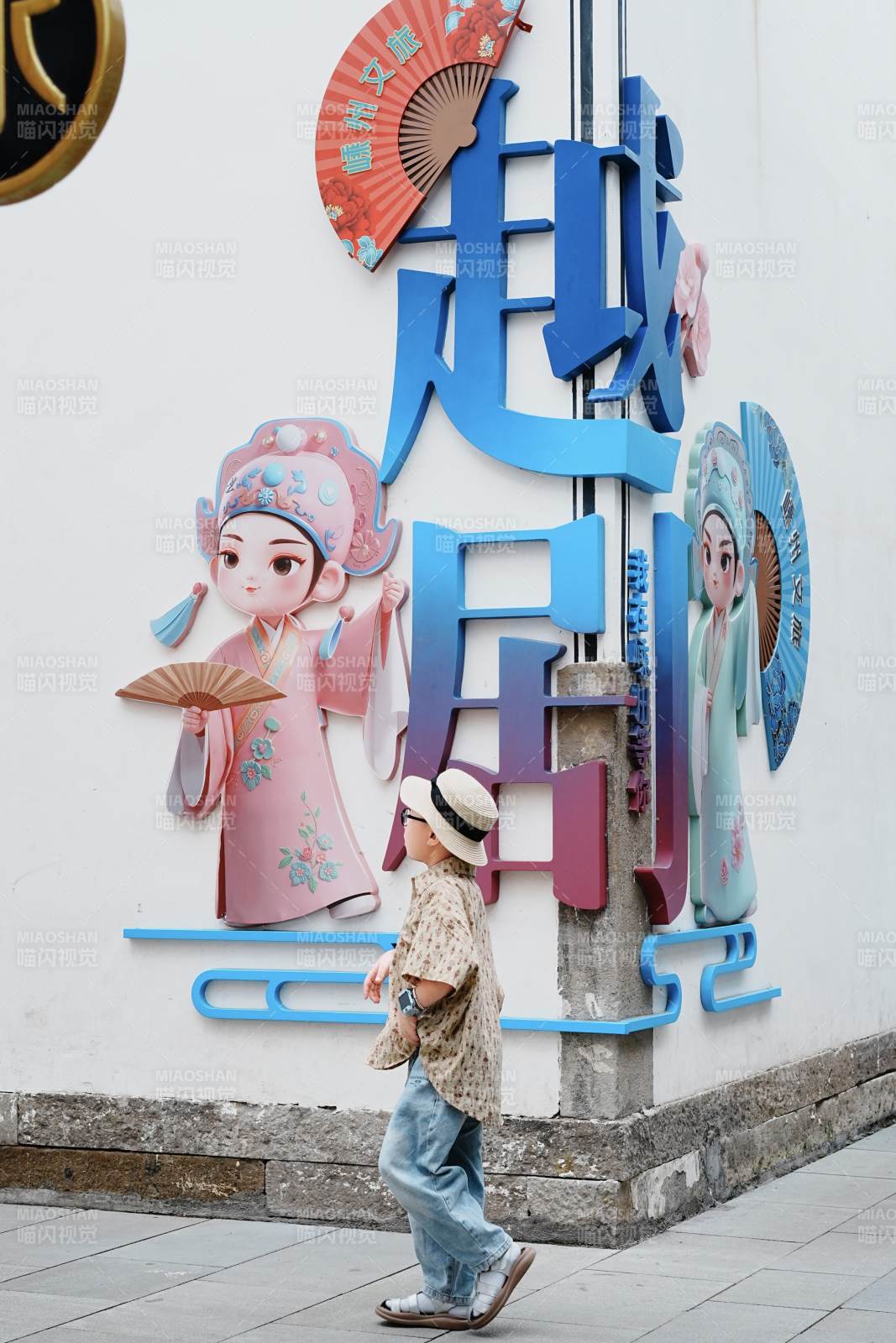 越剧文化墙前行人走过图片