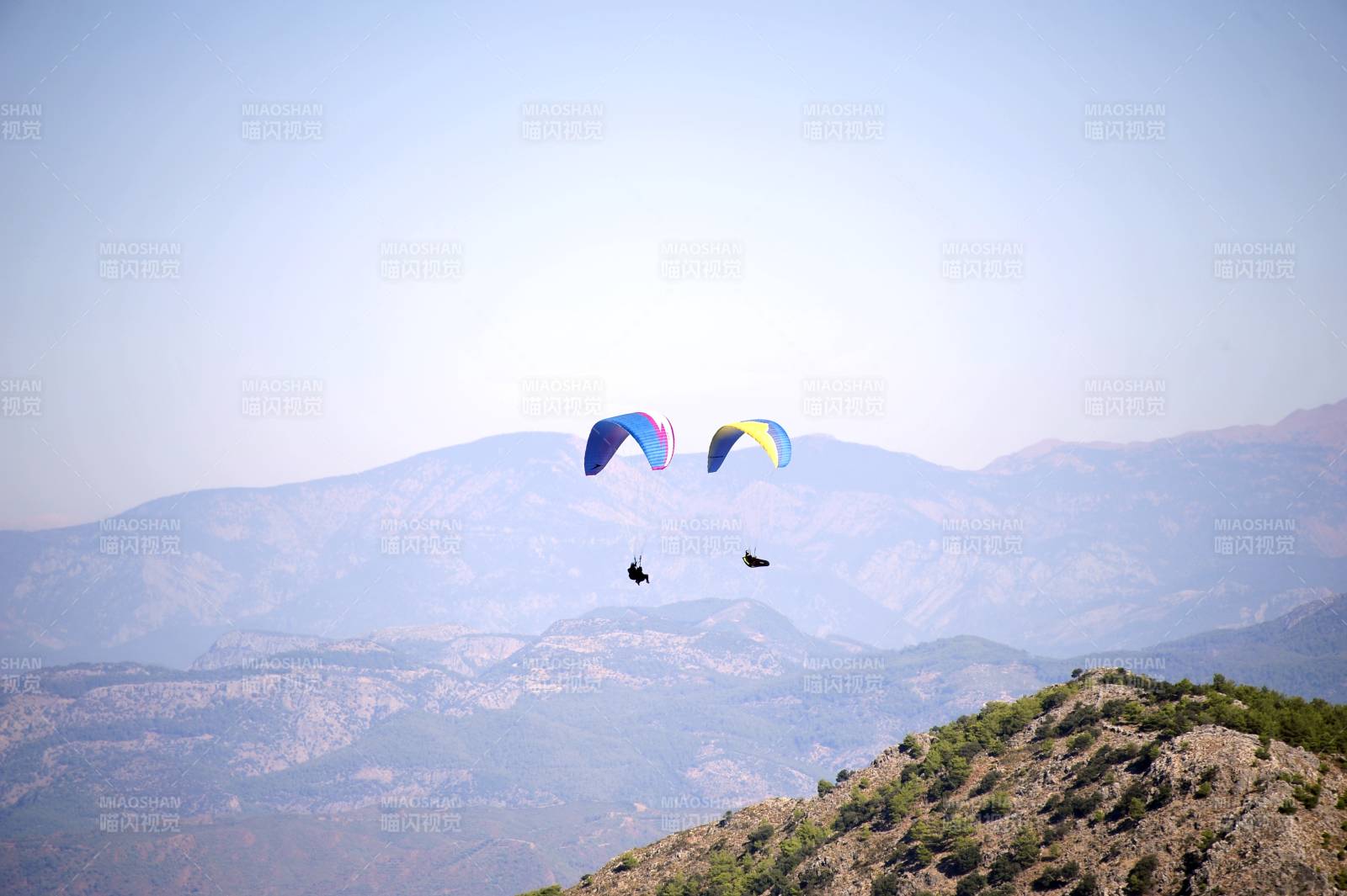 土耳其费特希耶双人滑翔伞翱翔山间图片