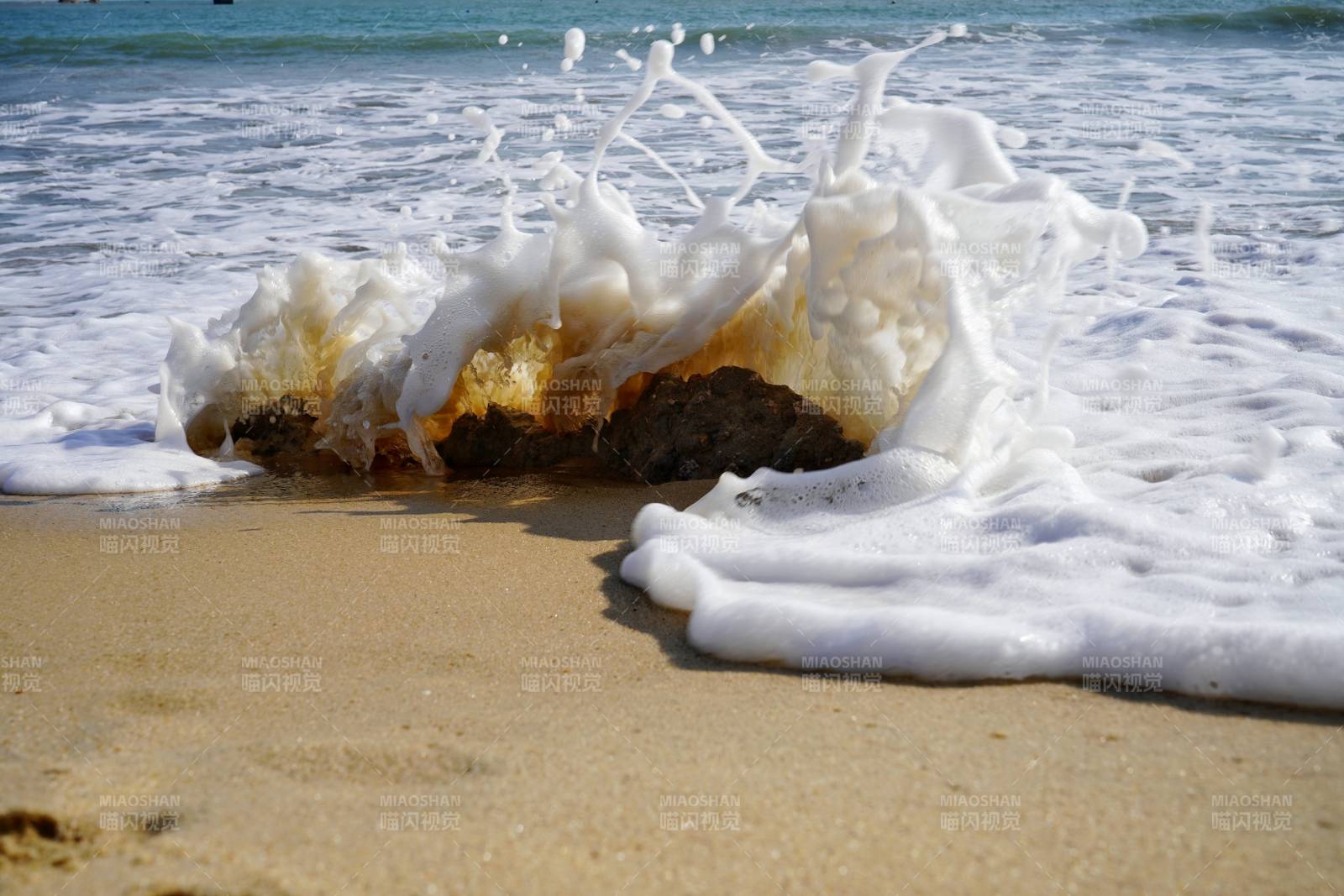 海浪拍打沙滩上的泡沫图片