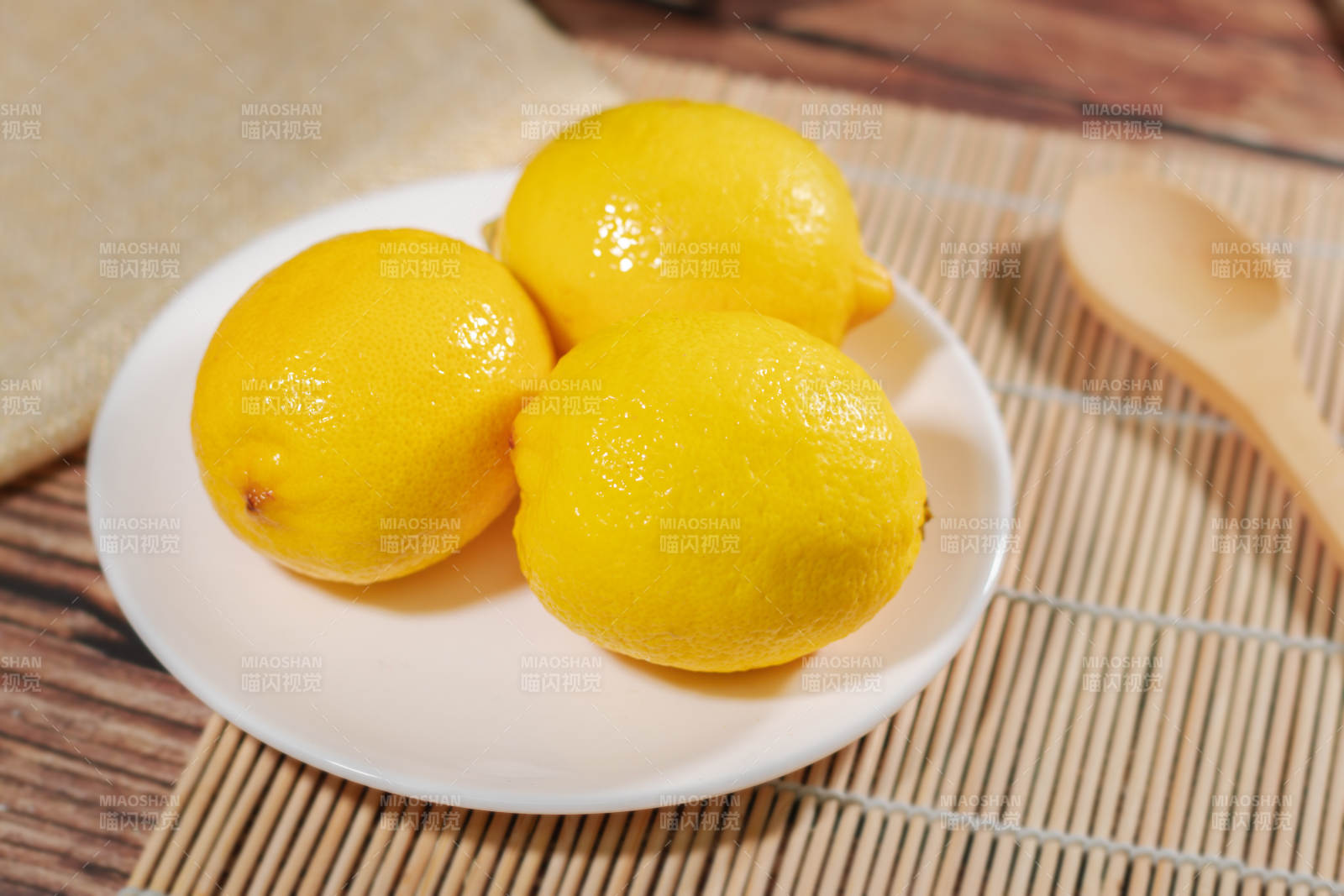 三颗柠檬静置盘中图片