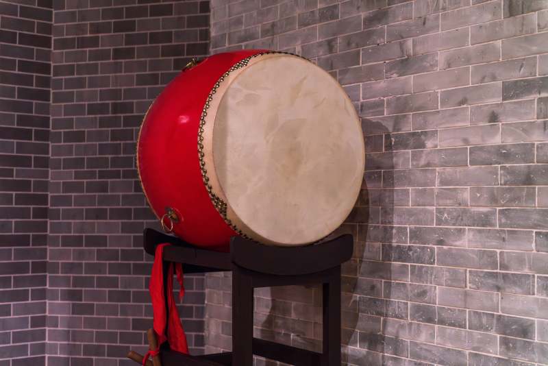 红鼓静立砖墙前图片