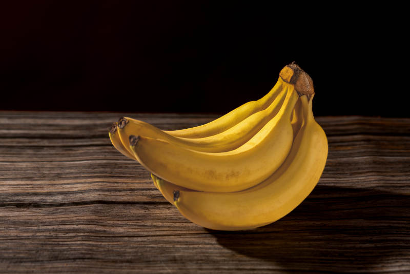 金黄香蕉静置木桌图片