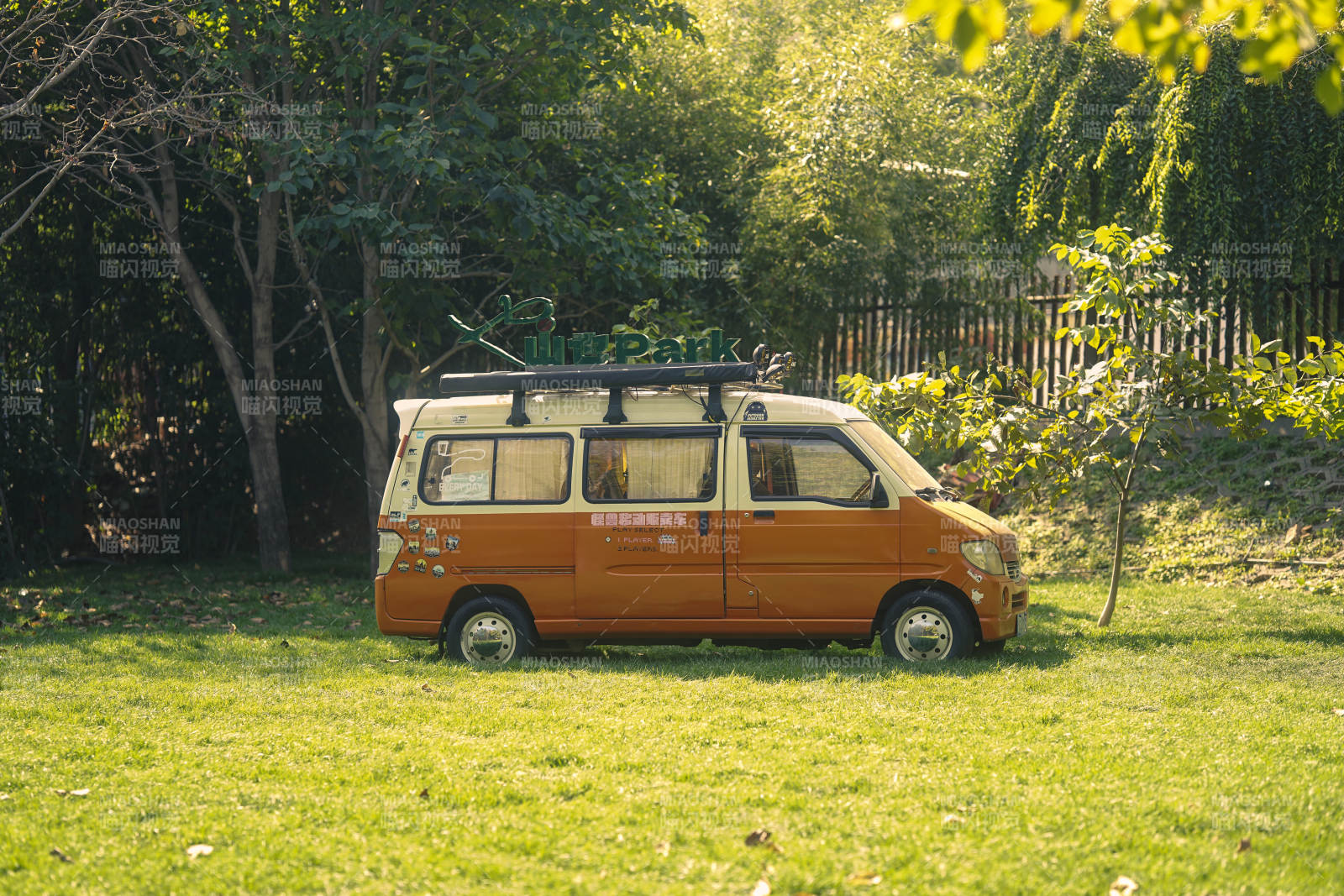 橙色面包车停绿草地图片