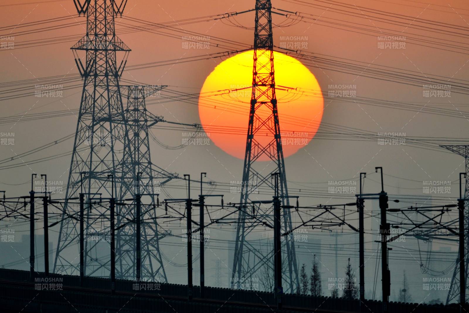 太阳冉冉升起下的电力塔图片
