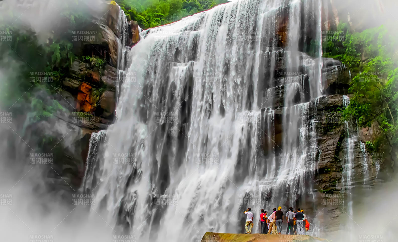 瀑布前的游客图片