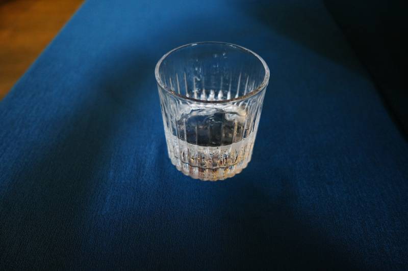 透明玻璃杯静置深蓝布上图片