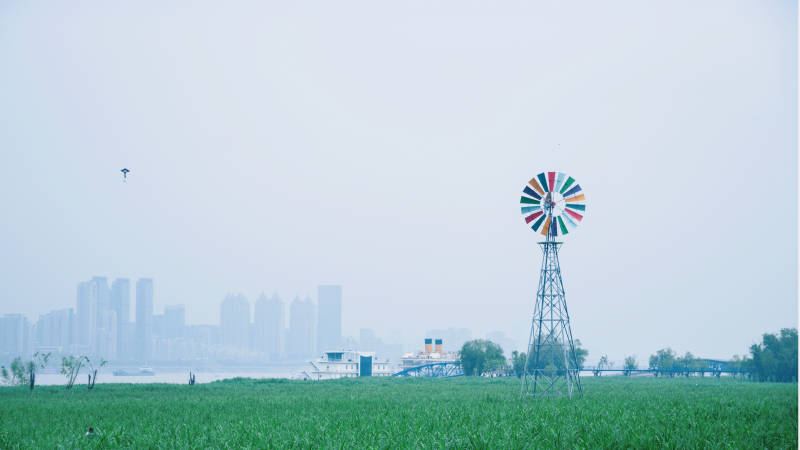 风车绿野城市远影图片