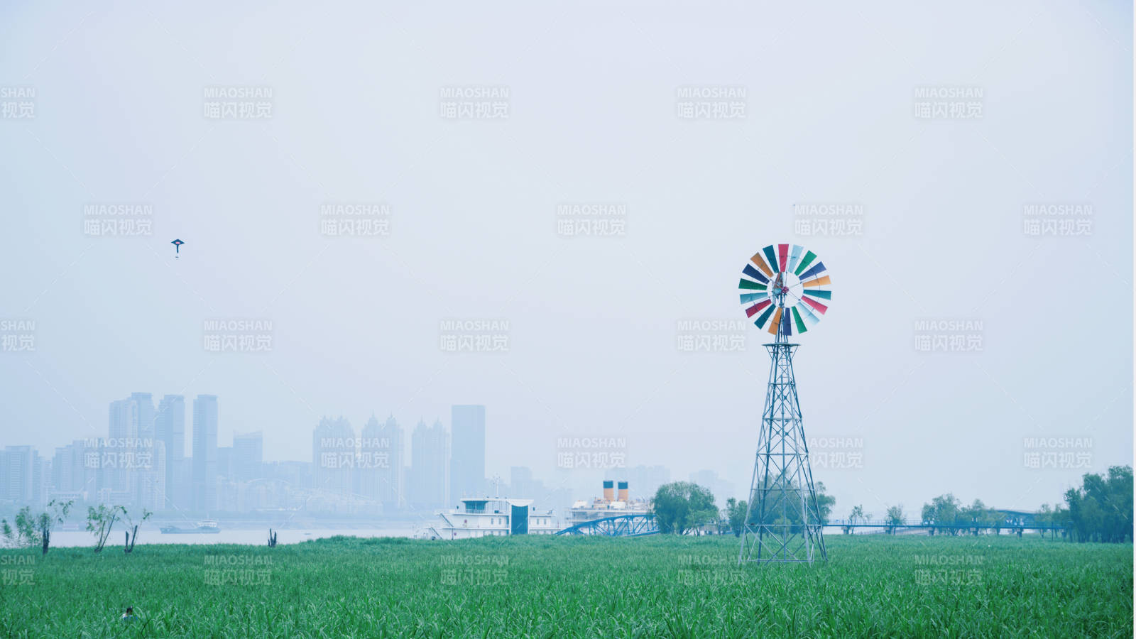 风车绿野城市远影图片