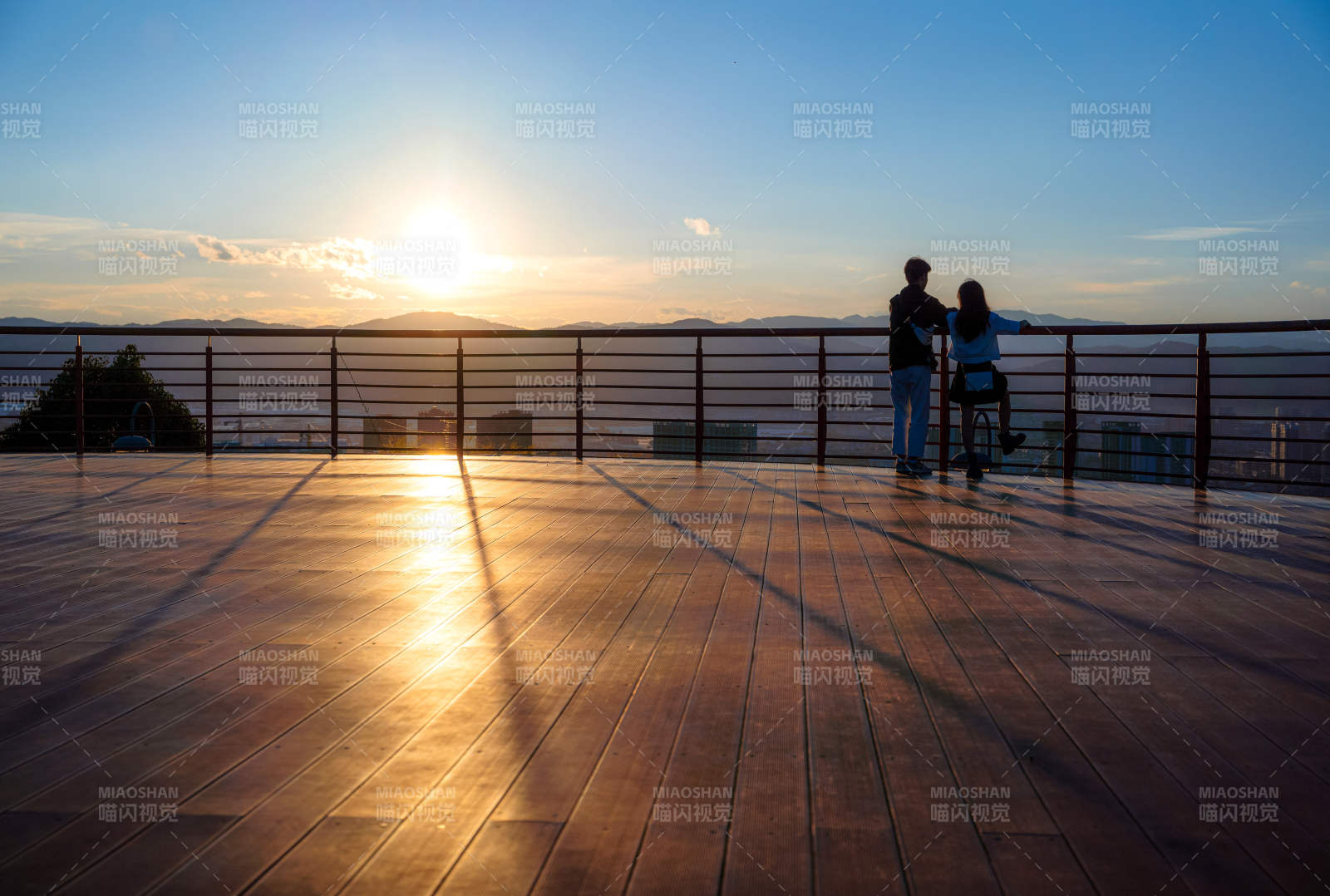 夕阳下观景台的恋人剪影图片