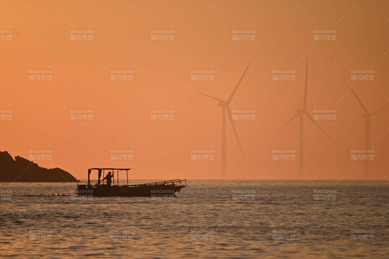 夕阳下的风车与渔船图片