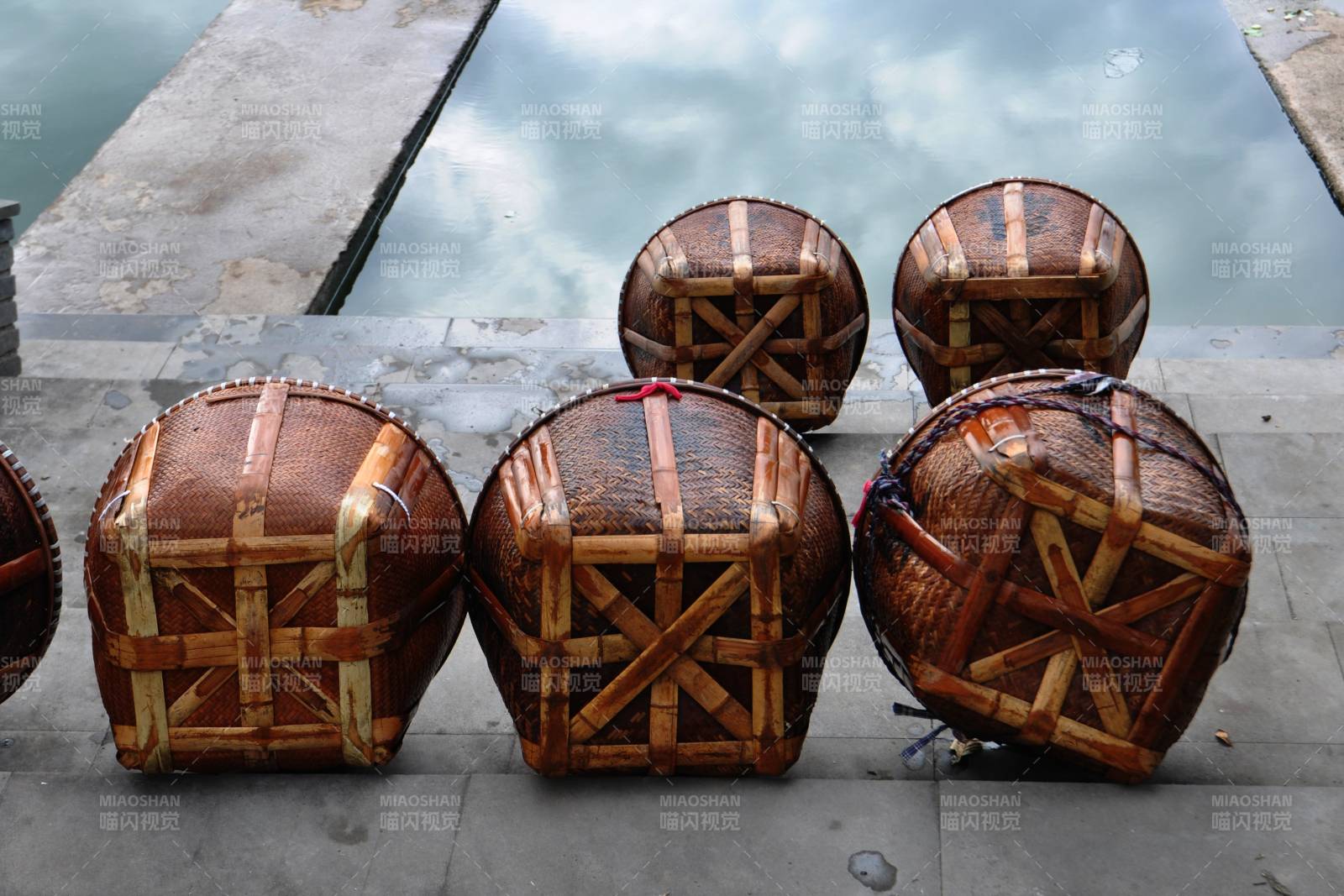 竹编筐子静置池边图片