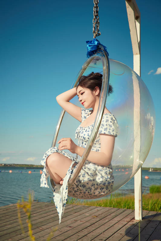 草原湖畔打卡点游玩拍照的东方美女图片