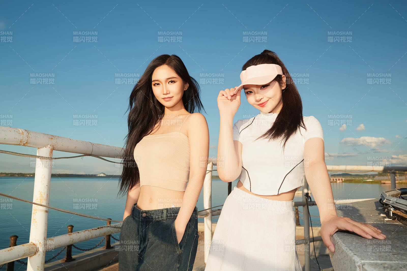 盛夏在景区湖边灯塔上拍照游玩的美女们图片