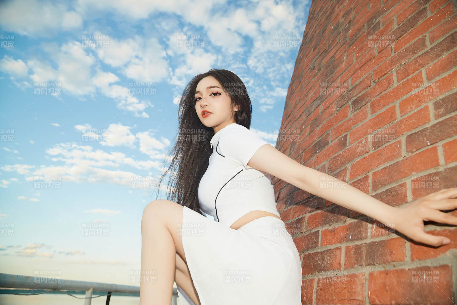 盛夏在景区湖边灯塔上拍照游玩的美女图片