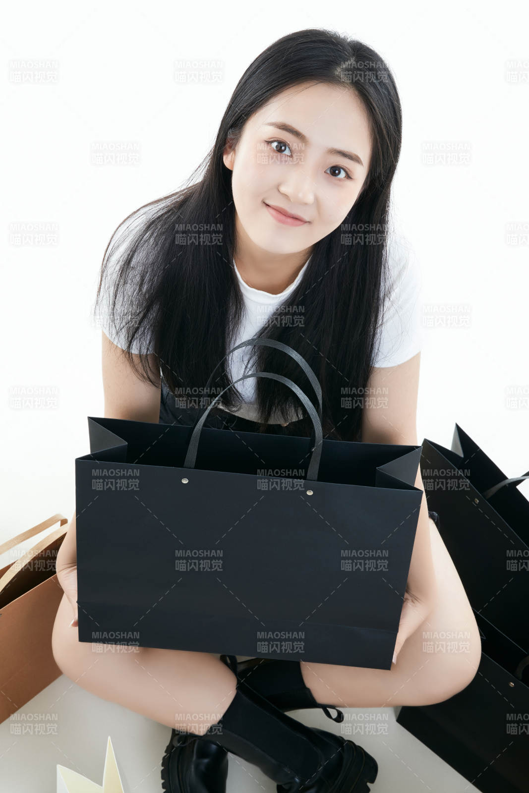 白色背景下手提购物袋时尚美丽的亚洲少女图片