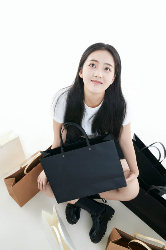 白色背景下手提购物袋时尚美丽的亚洲少女图片