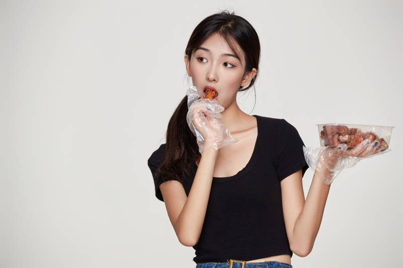 大吃特吃猪蹄块的亚洲可爱少女人像图片