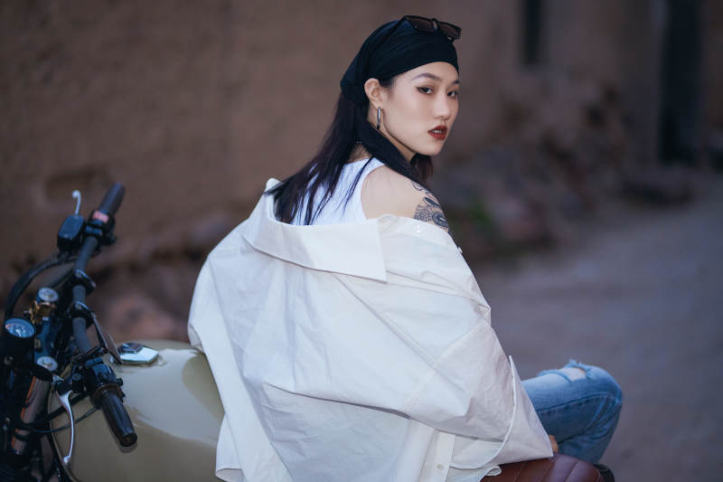 骑在复古摩托车上的时尚亚洲少女图片