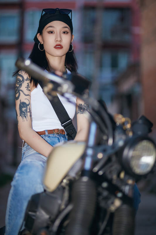 骑在复古摩托车上的时尚亚洲少女图片
