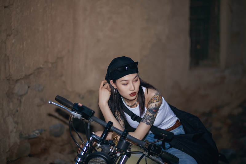 骑在复古摩托车上的时尚亚洲少女图片