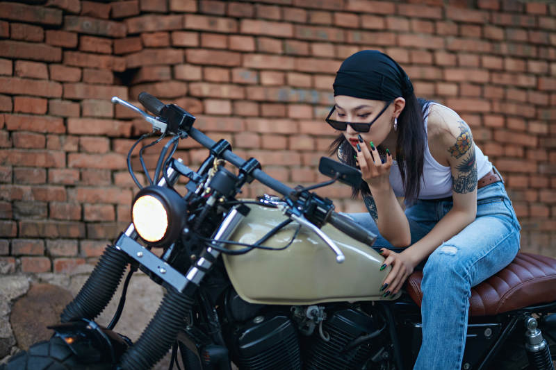 骑在复古摩托车上的时尚亚洲少女图片