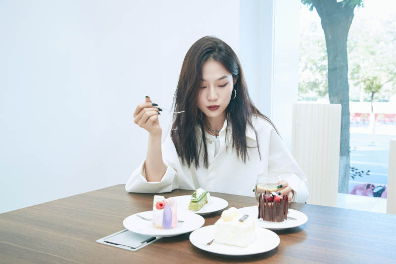 在烘焙店吃蛋糕喝饮料的可爱亚洲少女图片