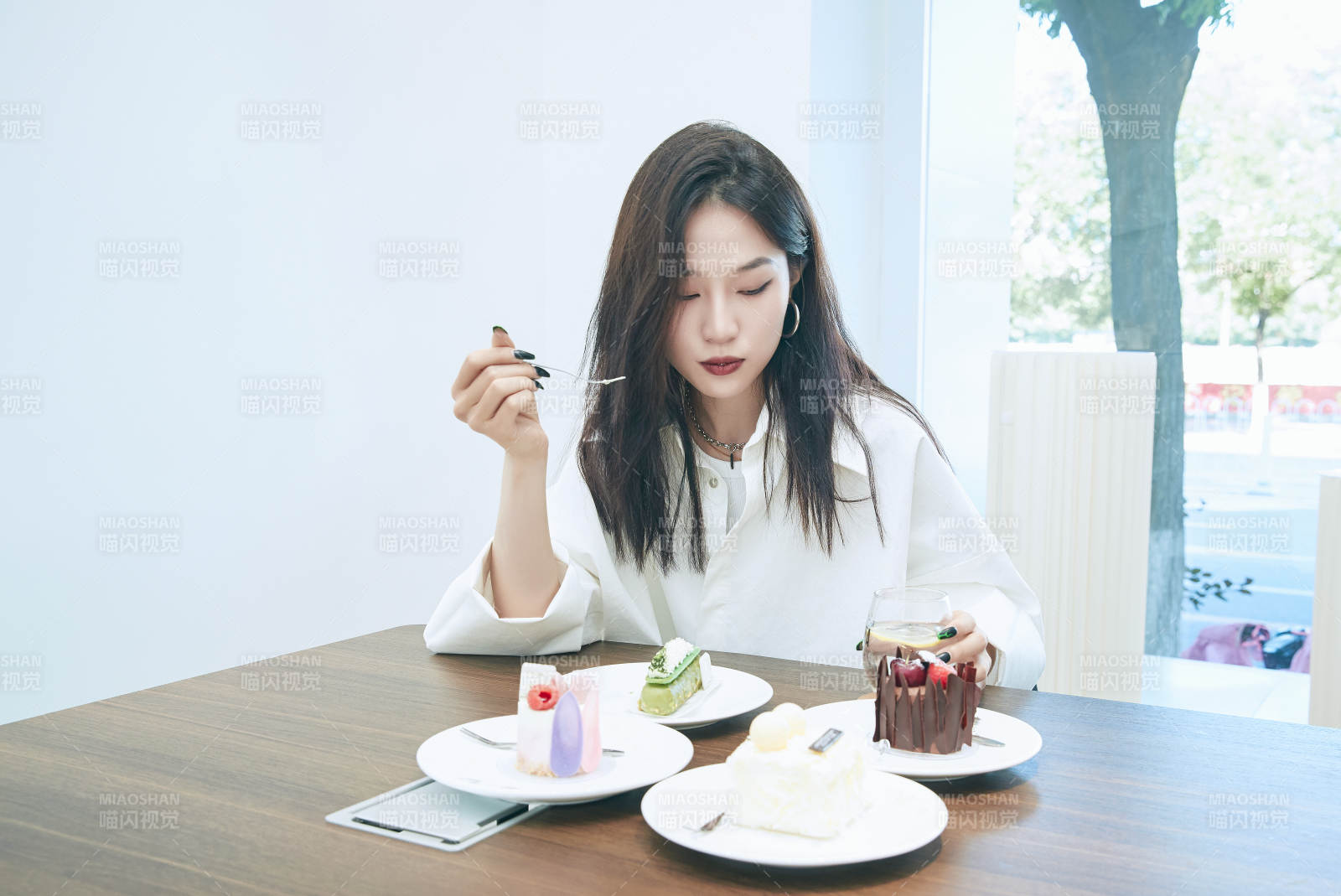 在烘焙店吃蛋糕喝饮料的可爱亚洲少女图片