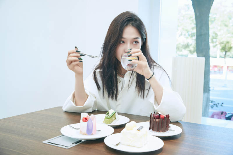 在烘焙店吃蛋糕喝饮料的可爱亚洲少女图片