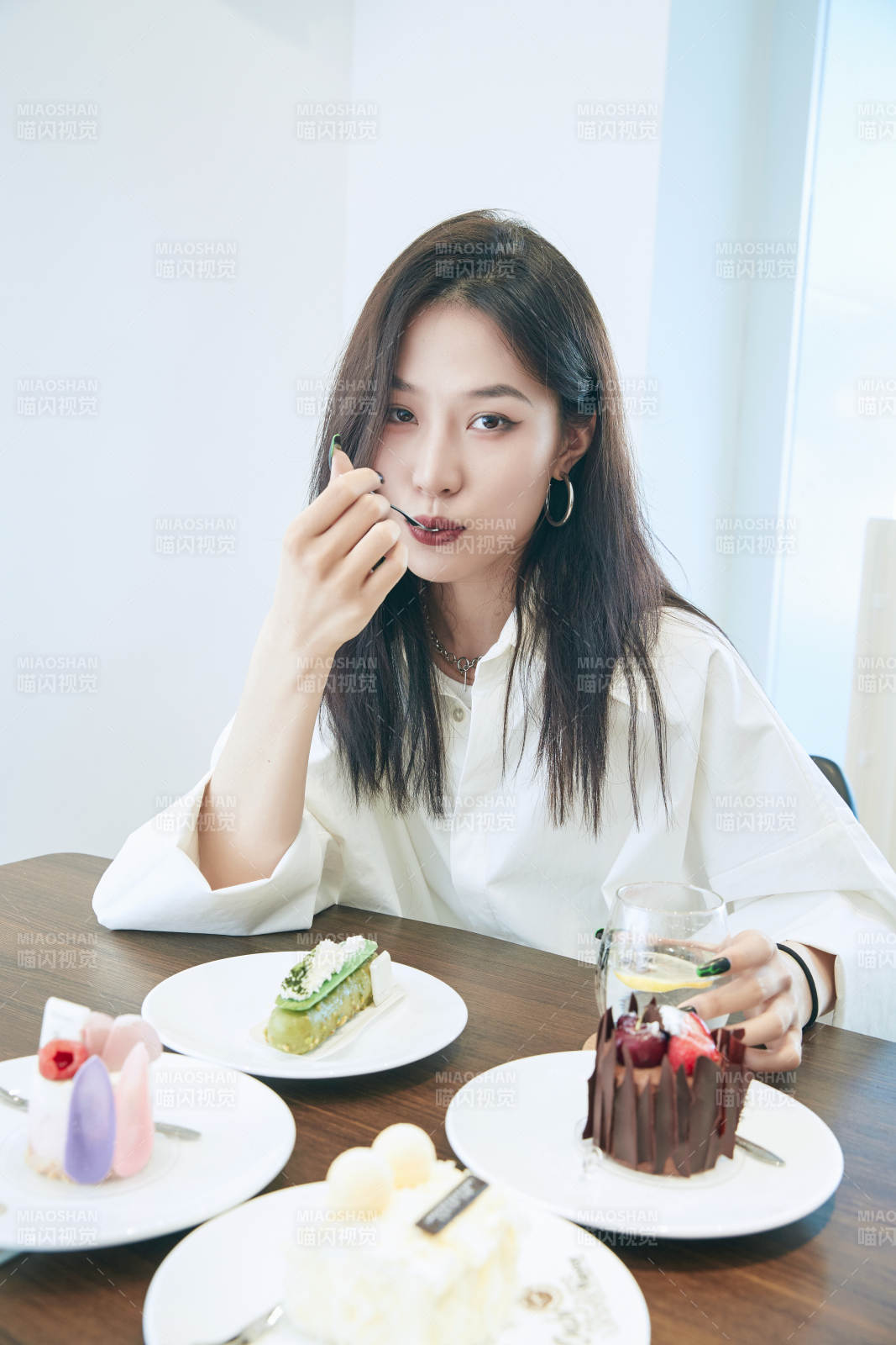 在烘焙店吃蛋糕喝饮料的可爱亚洲少女图片