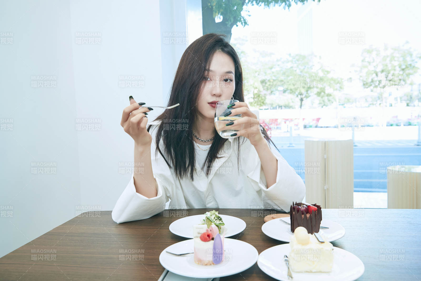 在烘焙店吃蛋糕喝饮料的可爱亚洲少女图片