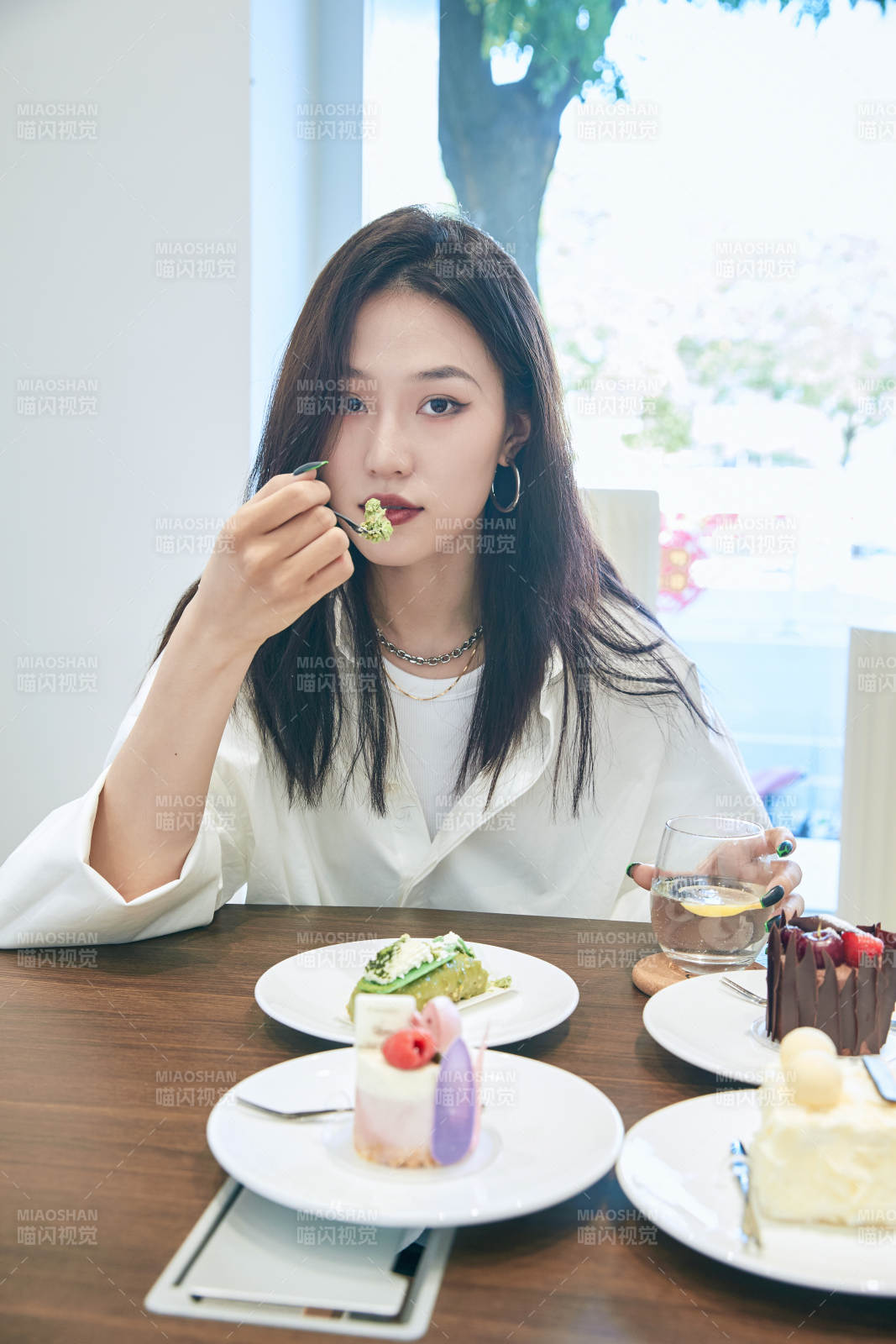 在烘焙店吃蛋糕喝饮料的可爱亚洲少女图片