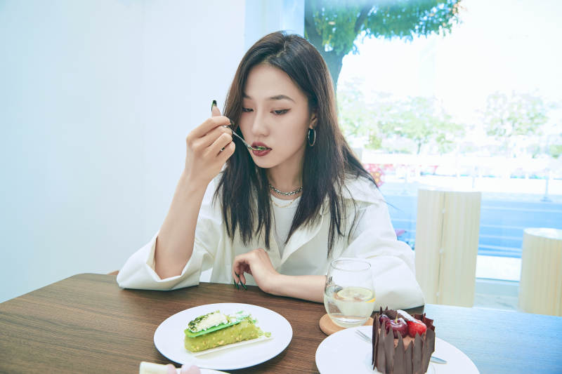 在烘焙店吃蛋糕喝饮料的可爱亚洲少女图片