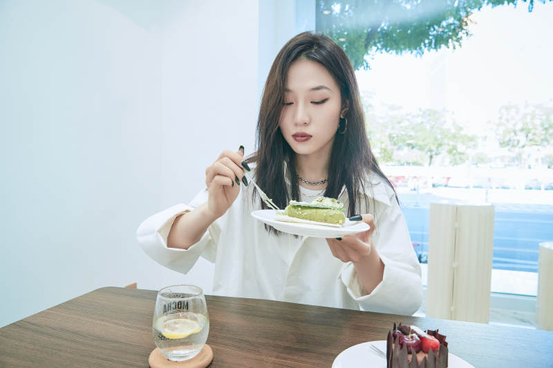 在烘焙店吃蛋糕喝饮料的可爱亚洲少女图片