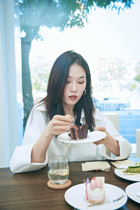 在烘焙店吃蛋糕喝饮料的可爱亚洲少女图片