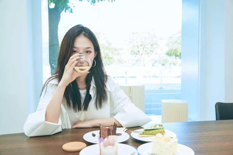 在烘焙店吃蛋糕喝饮料的可爱亚洲少女图片