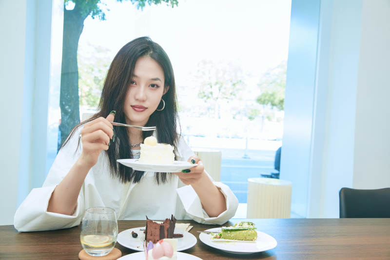 在烘焙店吃蛋糕喝饮料的可爱亚洲少女图片