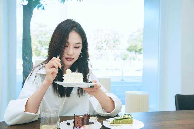 在烘焙店吃蛋糕喝饮料的可爱亚洲少女图片