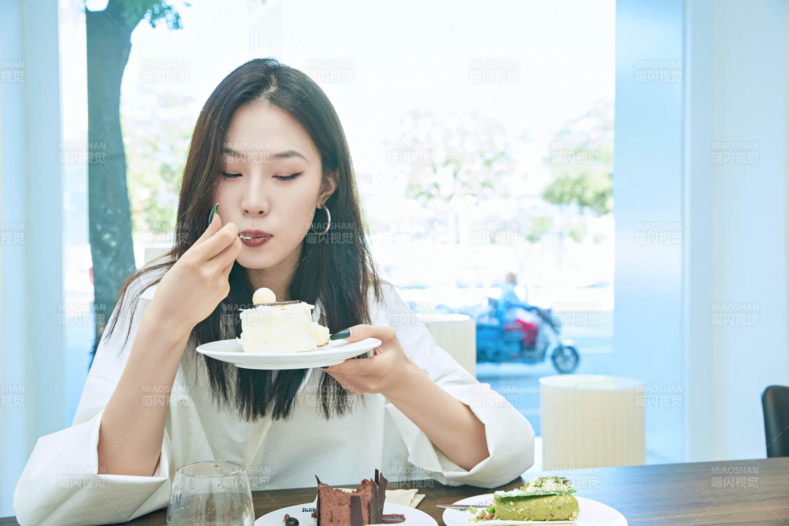 在烘焙店吃蛋糕喝饮料的可爱亚洲少女图片