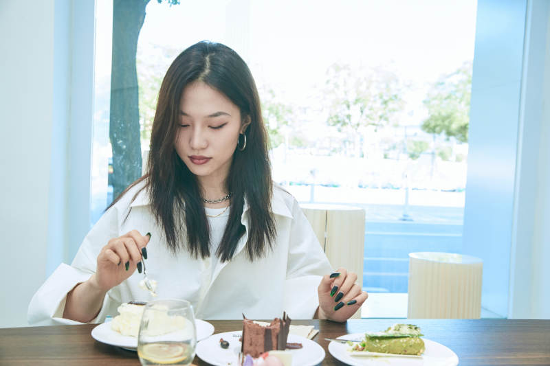 在烘焙店吃蛋糕喝饮料的可爱亚洲少女图片