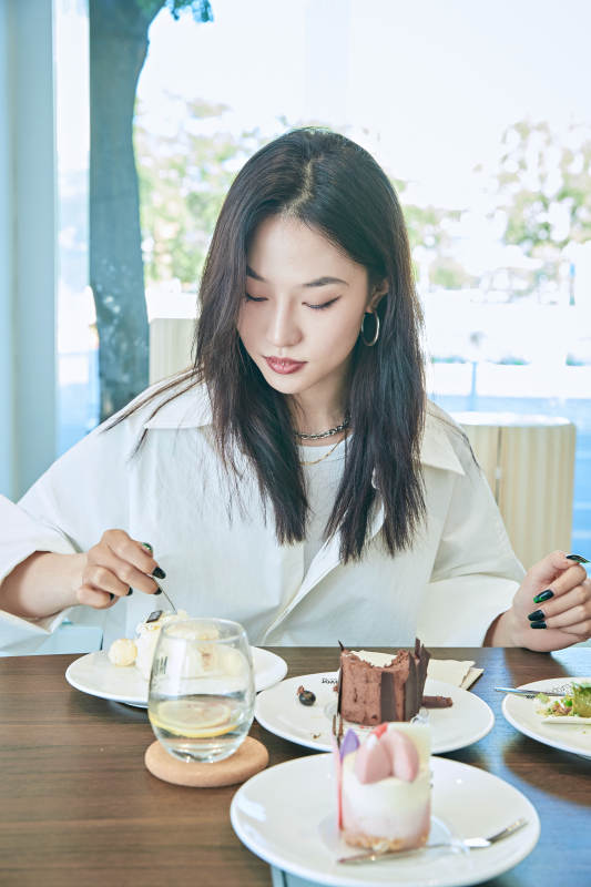 在烘焙店吃蛋糕喝饮料的可爱亚洲少女图片