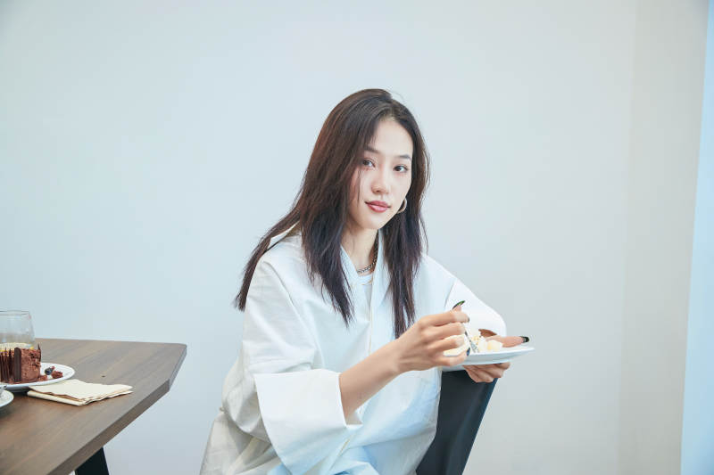 在烘焙店吃蛋糕喝饮料的可爱亚洲少女图片