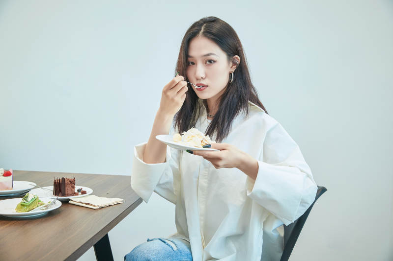 在烘焙店吃蛋糕喝饮料的可爱亚洲少女图片