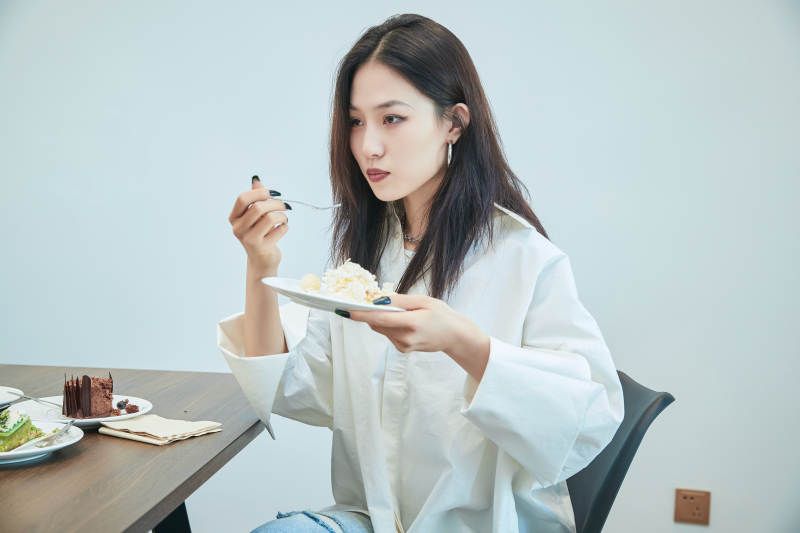 在烘焙店吃蛋糕喝饮料的可爱亚洲少女图片