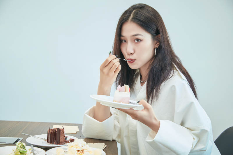 在烘焙店吃蛋糕喝饮料的可爱亚洲少女图片