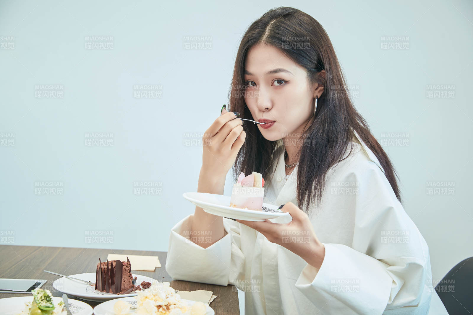 在烘焙店吃蛋糕喝饮料的可爱亚洲少女图片